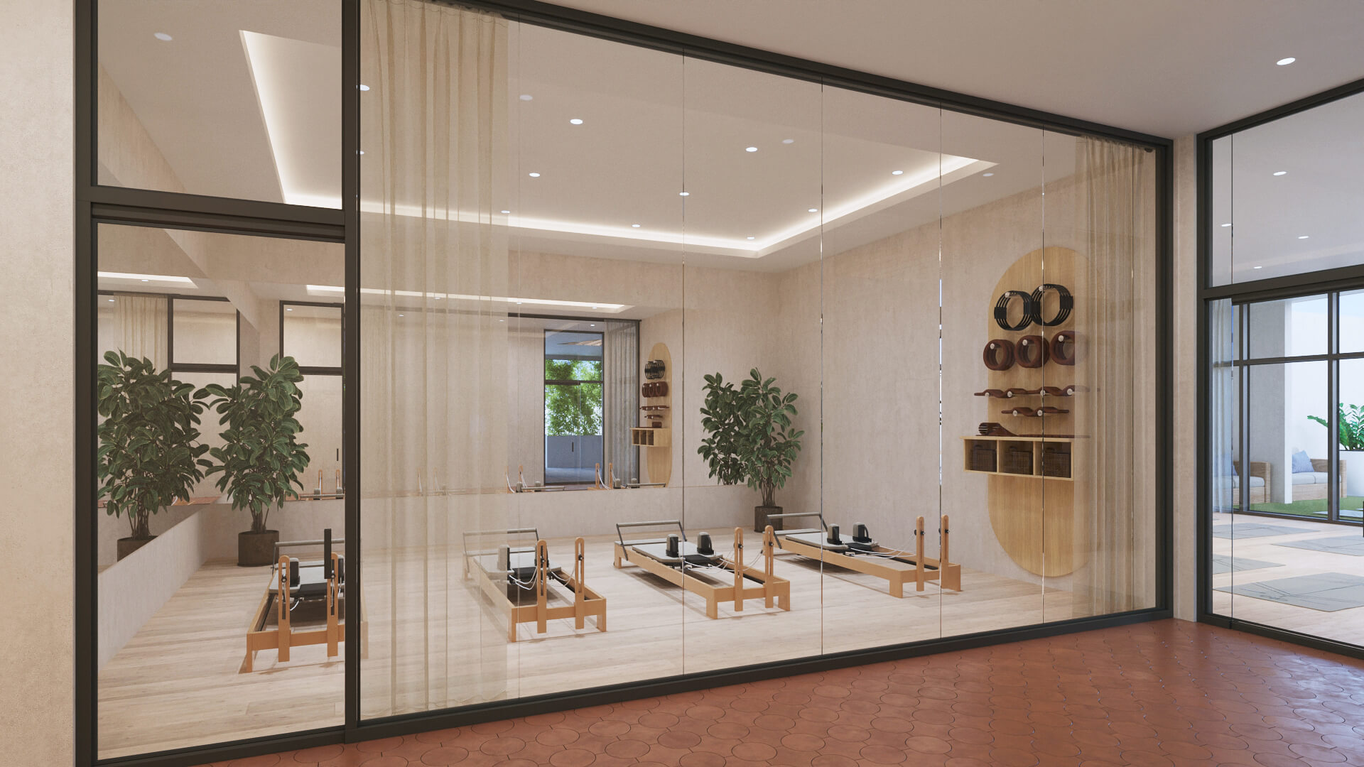 right Pilates studio viewed through a glass wall, containing three reformer machines
