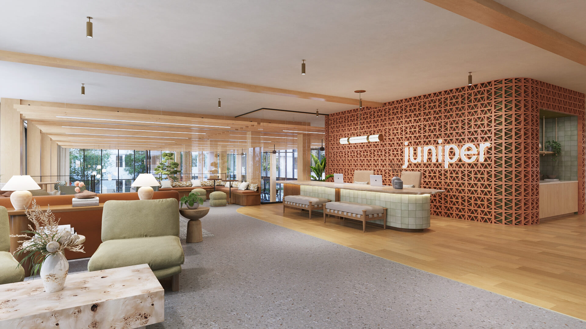 Modern student housing reception lobby featuring a front desk backed by a terracotta geometric brick wall with the word juniper illuminated
